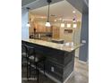 Kitchen featuring an island, breakfast bar, wooden cabinets, and modern appliances at 22988 W Twilight Trl, Buckeye, AZ 85326