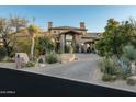 Inviting home entrance with a paved driveway and lush desert landscaping at 27914 N 100Th Pl, Scottsdale, AZ 85262