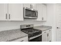 Close up on the kitchen with stainless steel microwave, stove and granite countertops at 32076 N 136Th Ave, Peoria, AZ 85383