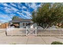 Beautiful home with a white picket fence and mature tree, offering a blend of classic charm and comfortable living at 7313 N 55Th Dr, Glendale, AZ 85301