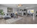 Open-concept living area with hardwood floors, modern decor, and seamless flow to dining and kitchen at 8064 E Madero Ave, Mesa, AZ 85209