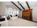 Spacious living room with vaulted ceiling, exposed beams, and a wall unit for storage at 8155 E Juan Tabo Rd, Scottsdale, AZ 85255