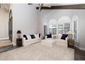 Bright living room featuring a ceiling fan, neutral carpeting, and large windows at 8155 E Juan Tabo Rd, Scottsdale, AZ 85255