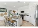 Modern kitchen with stainless steel appliances, granite countertops, and a center island with bar stools at 8486 W Mantle Way, Florence, AZ 85132