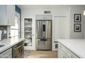 Modern kitchen featuring stainless steel appliances, white cabinets, and a stylish pantry door at 921 W University Dr # 1143, Mesa, AZ 85201