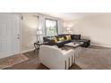 Inviting living room with a comfortable sectional sofa, plush armchair, and natural light from a window at 1575 W Hazelwood St, Phoenix, AZ 85015