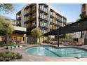 Community pool area featuring a large pool, lounge chairs, shaded seating, and landscaping at 19355 N 73Rd Way # 4016, Scottsdale, AZ 85255