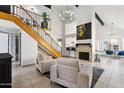 Bright living room features a fireplace, high ceilings, staircase, and natural light at 2138 W Beaubien Dr, Phoenix, AZ 85027