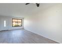Bright and airy living room featuring modern flooring, a large window, and a freshly painted white wall at 2440 N 22Nd Ave, Phoenix, AZ 85009