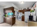 Functional kitchen featuring wooden cabinets, white appliances, and a peninsula counter at 3262 E Enid Ave, Mesa, AZ 85204