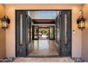 Elegant foyer with decorative iron doors opening to a view of the beautiful, landscaped outdoor living space beyond at 4448 E Camelback Rd # 16, Phoenix, AZ 85018