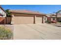 Home featuring a spacious driveway leading to a three-car garage with neutral-colored doors at 5102 E Libby St, Scottsdale, AZ 85254