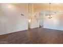 Open-concept living room with high ceilings, wood floors, and natural light from the archways and staircase at 62 N Amber Ct, Chandler, AZ 85225
