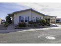 Charming home with lush landscaping, blue shutters, and a covered carport at 891 W Moon Shadow Dr, Casa Grande, AZ 85122