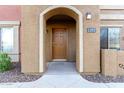 Close up of a condo entrance with a brown door, arched entryway, and the unit number displayed at 900 S 94Th St # 1203, Chandler, AZ 85224