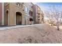 Multi-story condo building featuring colorful facades, private arched entryways, and desert landscaping at 900 S 94Th St # 1203, Chandler, AZ 85224