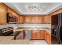 Well-equipped kitchen with wood cabinets, granite countertops, and stainless steel appliances at 1051 S Dobson Rd # 137, Mesa, AZ 85202