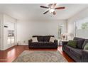 Cozy living room featuring wood floors, neutral walls, ceiling fan, and comfortable sofas at 1051 S Dobson Rd # 137, Mesa, AZ 85202