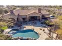 Expansive aerial view of the pool, backyard, and patio of this beautiful desert property at 14475 E Cortez Dr, Scottsdale, AZ 85259