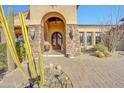 Close up of the desert home's entryway, displaying a brick driveway and desert foliage at 14475 E Cortez Dr, Scottsdale, AZ 85259