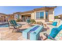 Inviting outdoor living area with comfortable seating, a modern fire pit, and pool, perfect for entertaining guests at 15313 S 180Th Ave, Goodyear, AZ 85338