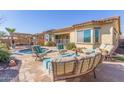 Relaxing backyard featuring a pool, desert landscaping, outdoor seating, grill, and ample space for entertaining at 15313 S 180Th Ave, Goodyear, AZ 85338