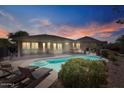Resort-style backyard featuring a refreshing swimming pool, lounge chairs, and a relaxing hot tub at 15442 W Sells Dr, Goodyear, AZ 85395