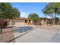 Attractive single-story home showcasing desert landscaping, a spacious driveway, and a two-car garage at 15442 W Sells Dr, Goodyear, AZ 85395