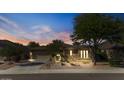Inviting exterior view of a single-story home featuring manicured desert landscaping and warm accent lighting at 15442 W Sells Dr, Goodyear, AZ 85395