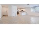 Bright, open-concept living room with tile floors connecting to a modern kitchen with stainless steel appliances at 15564 W Williams St, Goodyear, AZ 85338