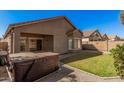 Private backyard with hot tub, grassy area, and low-maintenance landscaping at 17168 W Saguaro Ln, Surprise, AZ 85388