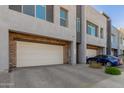 Modern townhome featuring a two-car garage with paved driveway and desert landscaping at 25318 N 19Th Dr, Phoenix, AZ 85085