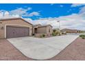 Single-story home featuring desert landscaping, a wide driveway, and convenient two-car garage access for easy parking at 41553 W Springtime Rd, Maricopa, AZ 85138