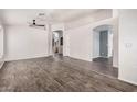 Spacious living room featuring hard flooring and multiple archways with a ceiling fan at 4325 E Cedarwood Ln, Phoenix, AZ 85048