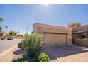 Spacious two-car garage with brick accents, paver driveway, and well manicured shrubbery at 6202 E Mckellips Rd # 171, Mesa, AZ 85215