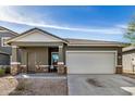 Charming single-story home featuring a two-car garage and covered front porch at 6513 W Latona Rd, Laveen, AZ 85339