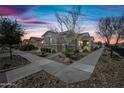 Inviting single-story home at dusk showcasing manicured landscaping, a stone facade, and warm lighting at 10726 E Tallahassee Ave, Mesa, AZ 85212