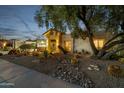 Charming desert home with desert landscaping and mature tree, creating a serene and inviting entry at 10810 E San Salvador Dr, Scottsdale, AZ 85259