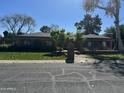 Lovely brick home showcases a well-kept lawn and established trees, offering a serene and picturesque setting at 115 W Rose Ln, Phoenix, AZ 85013