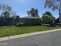 Beautiful single-story home boasts a lush green lawn and mature landscaping, adding to its inviting exterior at 115 W Rose Ln, Phoenix, AZ 85013
