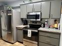 Well-lit kitchen with stainless steel appliances and gray cabinetry offering ample storage at 13801 N 111Th Ave, Sun City, AZ 85351