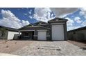 Beautiful single-Gathering home with a three-car garage, desert landscaping, and a paver driveway at 15769 W Cheryl Dr, Waddell, AZ 85355