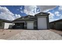 Charming single Gathering home features a two car garage, brick driveway, and low maintenance desert landscaping at 15769 W Cheryl Dr, Waddell, AZ 85355
