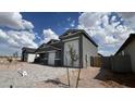 Modern single-story home with a three-car garage, desert landscaping, and a paver driveway at 15769 W Cheryl Dr, Waddell, AZ 85355