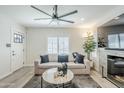 Bright living room featuring a modern ceiling fan, stone fireplace, and stylish furnishings at 1926 W Holly St, Phoenix, AZ 85009