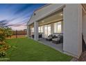 Inviting covered patio with outdoor seating, a lush lawn, and a secure fence, perfect for relaxation at 24441 N 142Nd Dr, Surprise, AZ 85387