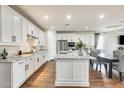 Modern kitchen boasts white cabinetry, granite countertops, stainless steel appliances, and a center island at 24441 N 142Nd Dr, Surprise, AZ 85387