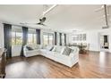 Bright and spacious living room featuring hardwood floors, a comfortable sectional sofa, and expansive windows at 24441 N 142Nd Dr, Surprise, AZ 85387