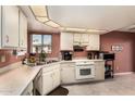 Bright kitchen with white cabinetry, white appliances, and tiled flooring at 25261 S Berry Brook Dr, Sun Lakes, AZ 85248