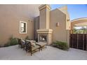 Cozy outdoor patio with a fireplace, seating, and privacy landscaping for relaxing evenings at 27000 N Alma School Pkwy # 1024, Scottsdale, AZ 85262